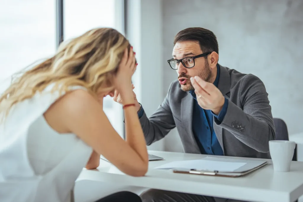 Furious businessman shout at female employee working in shared office